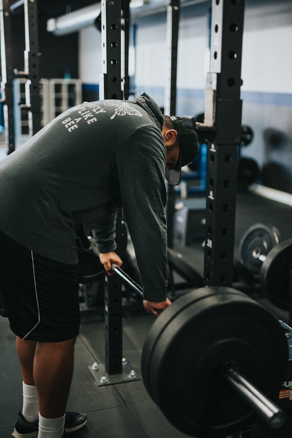 Man in grey t-shirt training with barbell